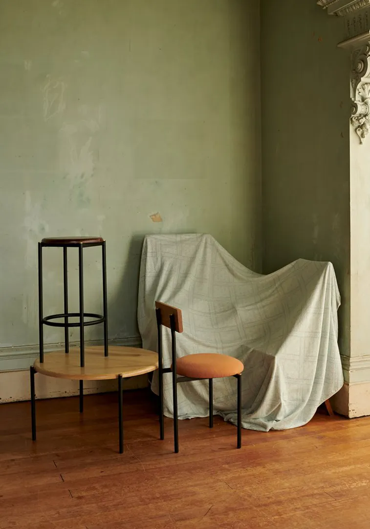 Volta chairs by Dowell Jones against draped fabric in empty room with green walls and timber floors.
