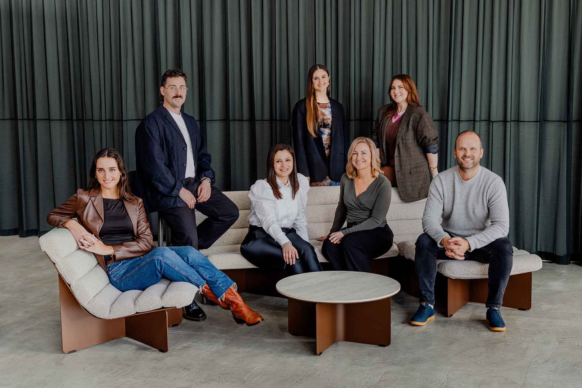 A portrait photo of the designfarm team seated around an outdoor setting.