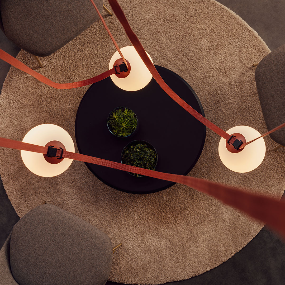 Overhead view of Plusminus pendant lighting by Vibia hanging above a seated lounge area with modern furniture
